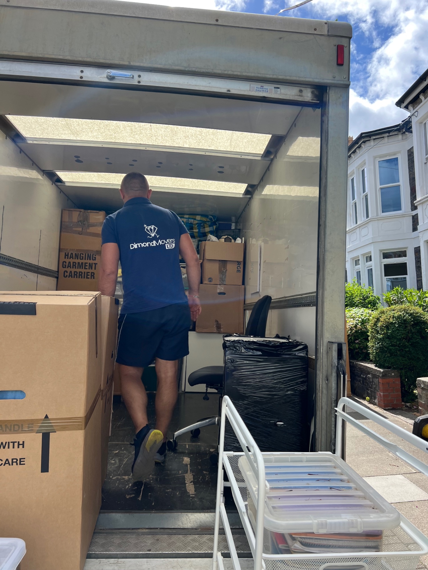 Professional loading during a Bristol house move branded polo and labelled boxes inside the Luton van