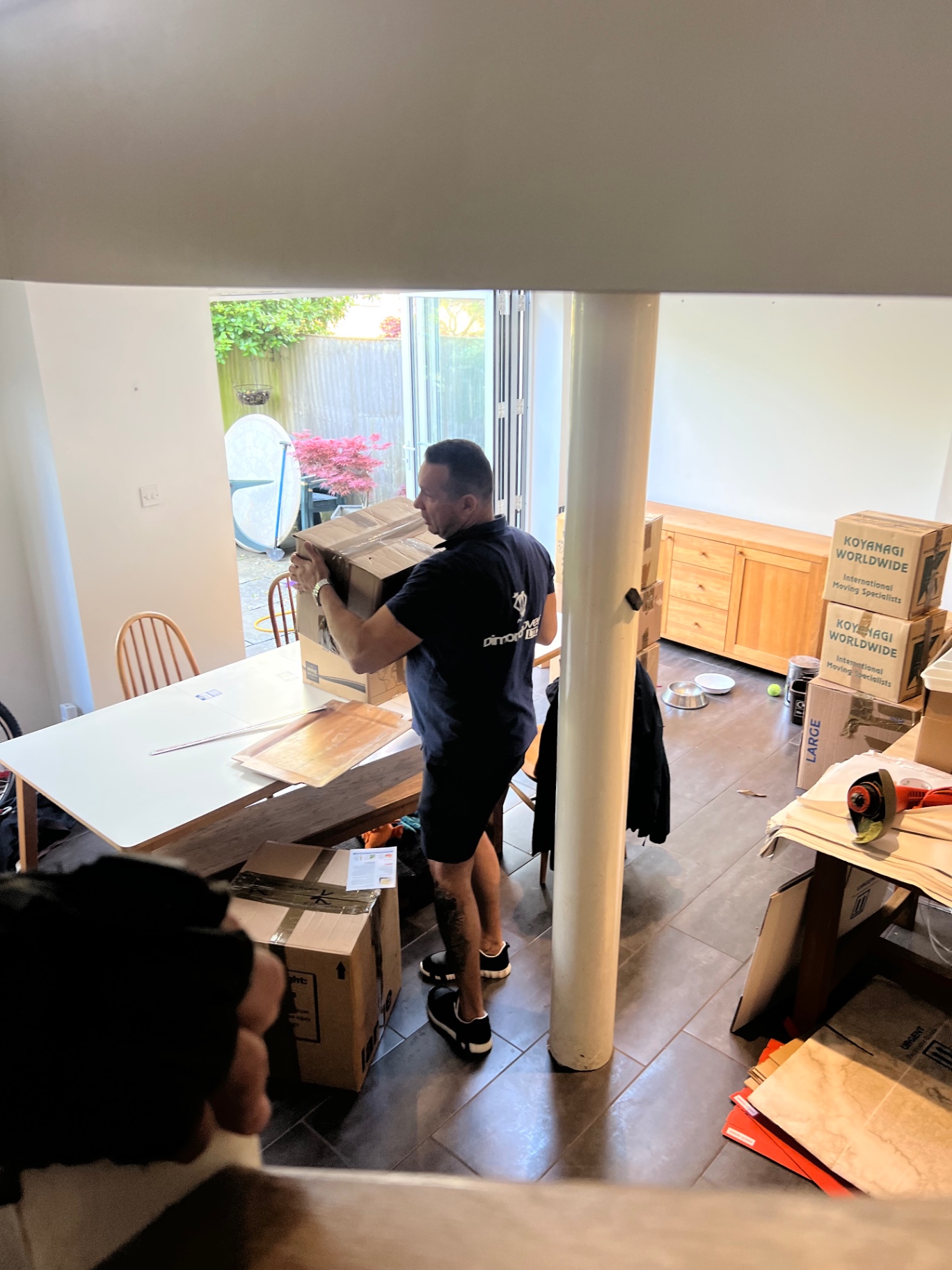 Dimond Movers carefully manoeuvring a chest of drawers along a Bristol garden path