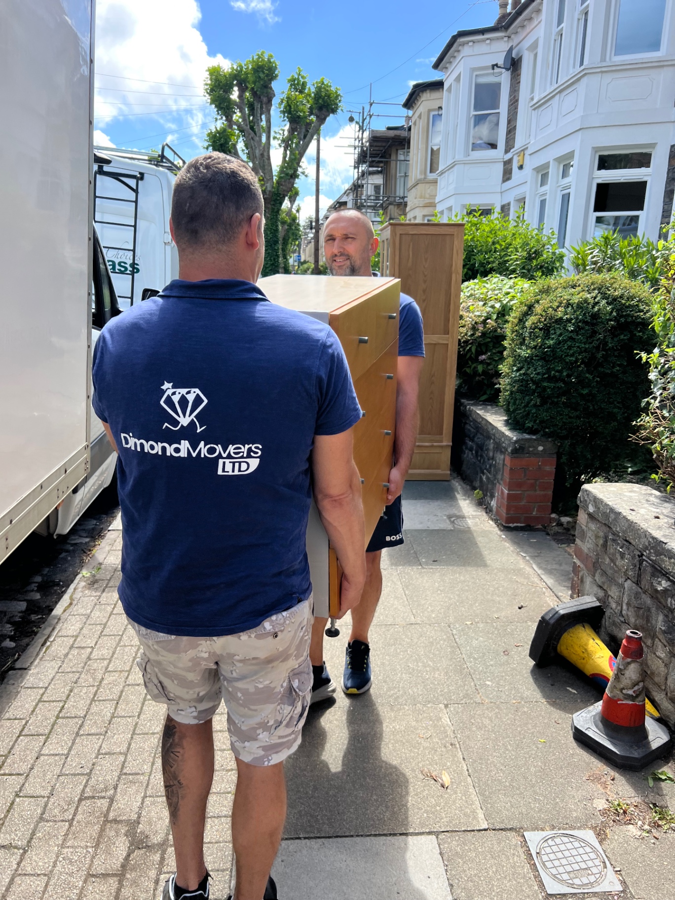 Real Bristol house removal Dimond Movers walking a chest of drawers from the property to the van