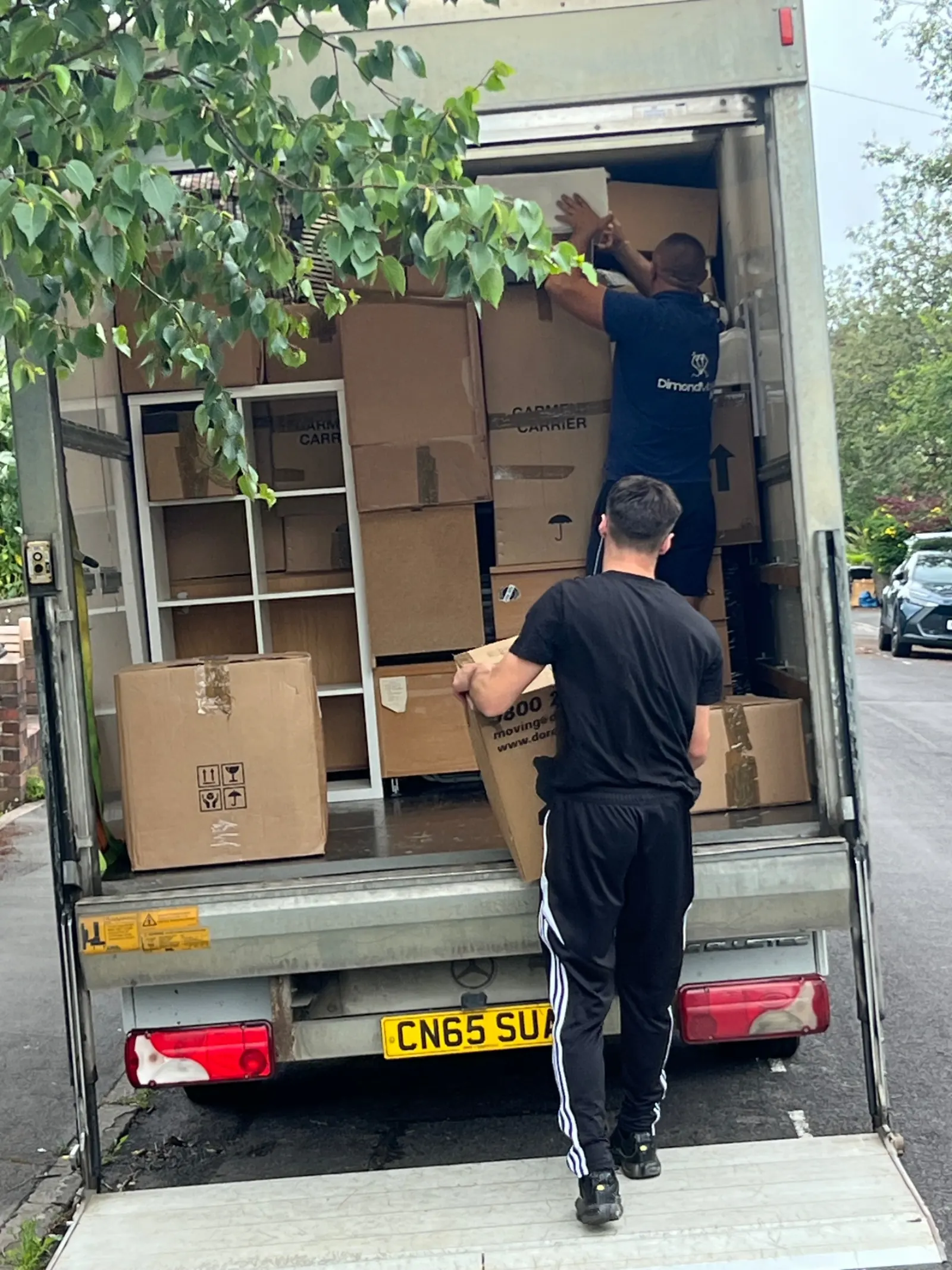 Dimond Movers crew loading a Luton van with carefully stacked boxes and furniture on a UK street
