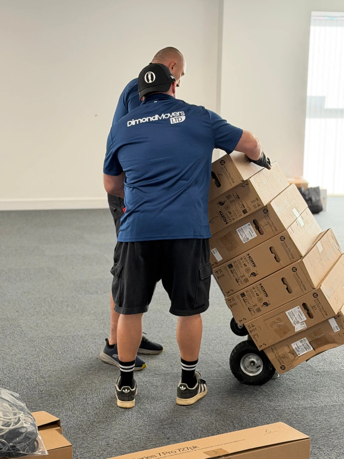 Dimond Movers crew using a trolley to move boxed equipment at Walter P Moore