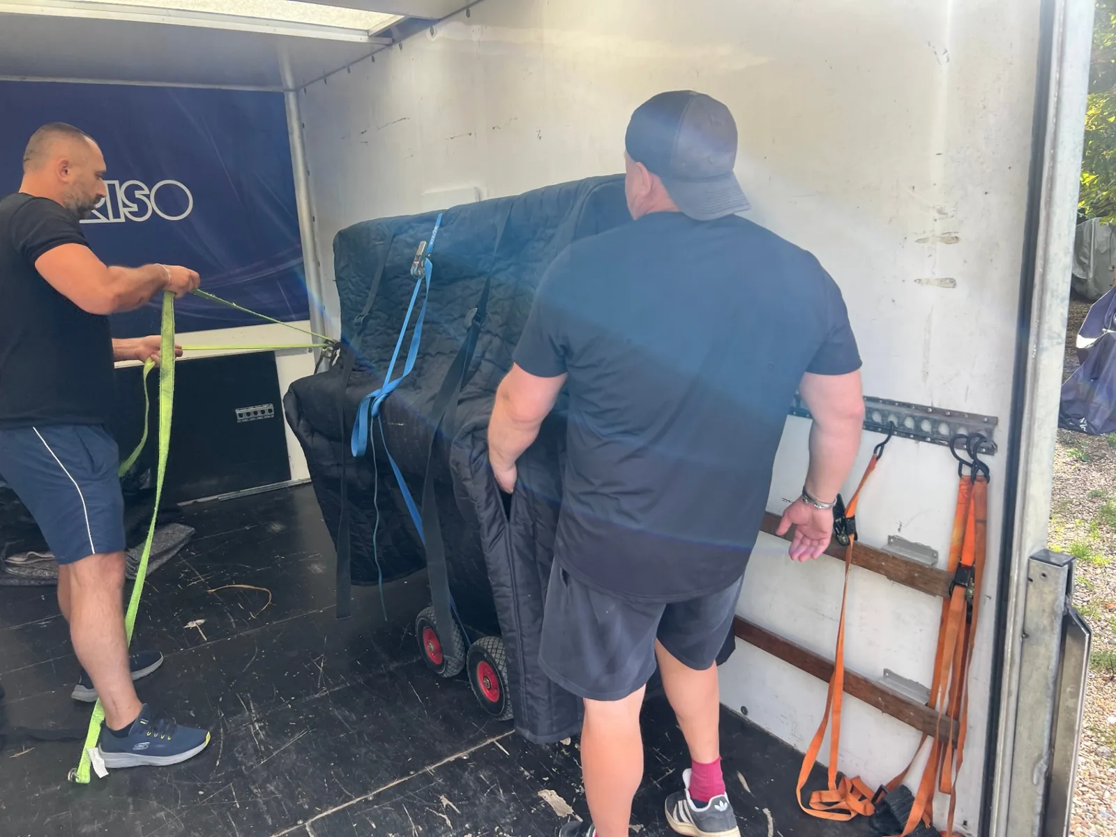 Dimond Movers movers loading a fully wrapped and strapped upright piano into a Luton removals truck
