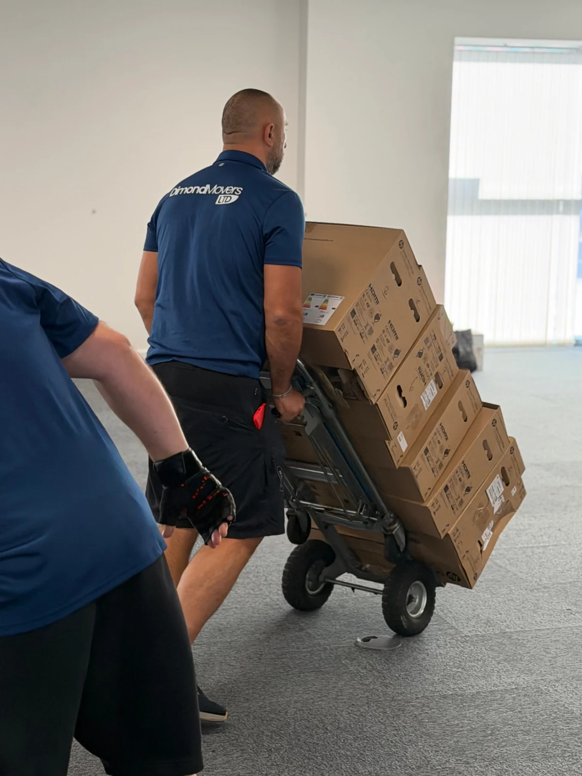 Dimond Movers team moving boxed office equipment by trolley during the Walter P Moore office relocation